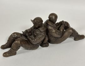 A modern cast resin group of WW II seated back to back airmen one with a dog, unmarked, (H x 17 cm x