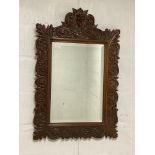 A late 19th century Bavarian/Black Forest wall hanging mirror, the oak frame carved with green man