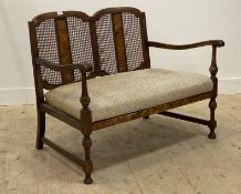 A 1930's walnut two seat sofa, the bergere panelled back over two open arms and a drop in