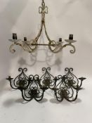 A set of five wrought iron twin branch wall sconces of scrolling form with verdigris finish, early
