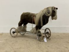 A vintage mohair pull along horse, moving on spoked chrome plated wheels with articulated front