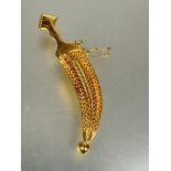 A Middle Eastern yellow metal Jambiya brooch with filigree scabbard and safety chain L x 5.7cm no