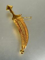 A Middle Eastern yellow metal Jambiya brooch with filigree scabbard and safety chain L x 5.7cm no
