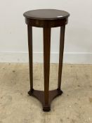 An early 20th century mahogany jardiniere stand, the circular top over three supports and a