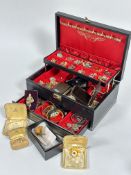 A black jewellery box containing a large collection of paste, gilt metal and ceramic clip on