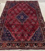 A Persian mahal joshagan carpet, the busy red field with floral motifs, lozenge medallion and