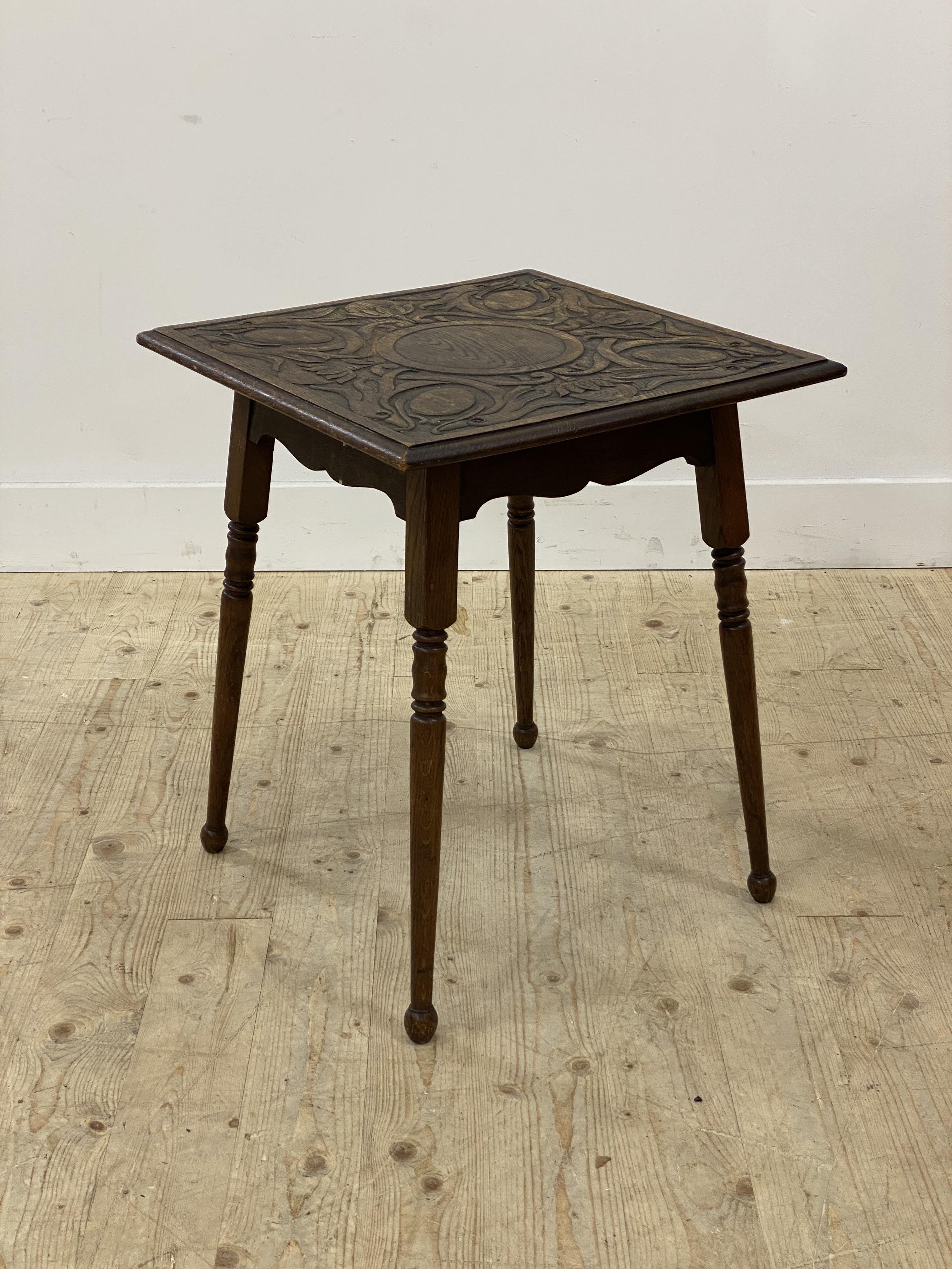 Early 20th century oak occasional table, the square top carved with stylised birds and scrolling
