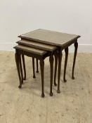 A walnut next of three tables, circa 1930's, with glass plate tops, raised on floral carved cabriole