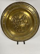A 19thc large circular chased brass plaque with a Chevalier and serving maid in French 18thc