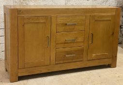 A contemporary light oak sideboard, fitted with three drawers and two cupboards, raised on stile