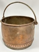 A large late 19thc copper studded log bin with folded rim and wrought iron loop handle and
