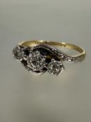 A 18ct gold and platinum set three stone old diamond set cross over ring in rub-over mounts, K/L 1.