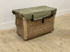 A large wicker laundry basket, mid 20th century, the green canvas covered top with hinged lid