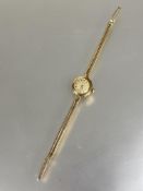 A ladys 9ct gold Baume vintage wristwatch with gilt dial on 9ct gold twin chain style strap and
