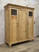 A Dutch pine two door armoire, 20th century, the projecting cornice above panelled centre door and