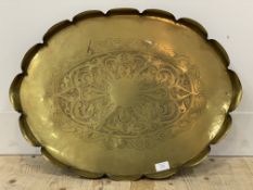 An eastern brass tray with scalloped edge. W68cm.
