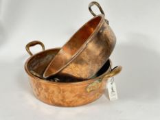A near pair of 19thc copper circular roasting dishes with twin loop handles handles to side, ex Lord