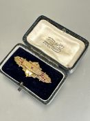 An Edwardian 9ct gold plaque brooch with central pink stone flanked by five small pink stones with