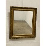 An early 20th century gilt composition and gesso wall mirror, the frame decorated with scrolling