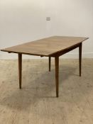 A mid century walnut duo drawer leaf extending dining table, the shaped rectangular top with inner