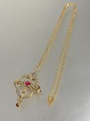 An Edwardian yellow metal open work scrolling pendant brooch set two pink gem stones with seed pearl