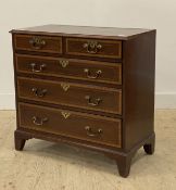 A George III mahogany chest of drawers, circa 1800, the satinwood cross banded top above two short