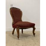 A Victorian walnut upholstered spoon back slipper chair, standing on cabriole front supports with