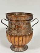An Eastern copper two handled urn, the rope patterned moulded lip above a scrolling border, with