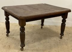 A Victorian oak wind out extending dining table, the rectangular top with canted corners raised on