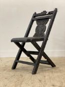 An Anglo-Indian carved hardwood folding chair, late 19th century, the frame profusely carved with