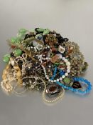 A collection of costume jewellery to include bead necklaces, baste and enamel brooches, paste