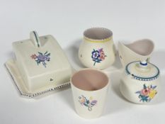 A Poole pottery butter dish and cover in the Art Deco style with hand painted floral sprays and