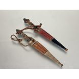 A pair of African steel bladed short daggers with leather and snake / lizard panels and leather