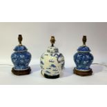 A pair of blue and white ceramic table lamps in the style of ginger jars with butterflies to the