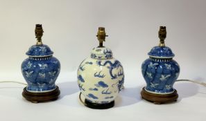 A pair of blue and white ceramic table lamps in the style of ginger jars with butterflies to the