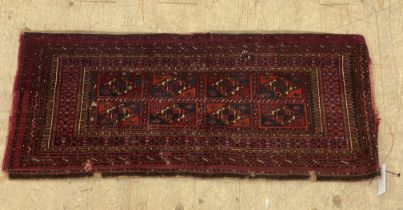 An Antique hand knotted Turkman Tekke bag face rug, the dark red field with eight panels having