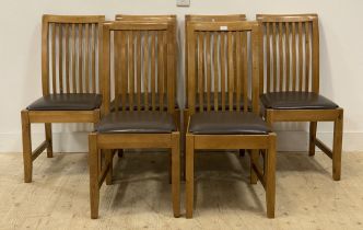 A set of six contemporary ash dining chairs, with brown leather upholstered seats, raised on