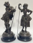 A pair of bronze patinated spelter figures in the Rococo manner, one of a gentleman, the other of a