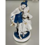 German Katzhutte porcelain figure group of a minstrel and lady with mask with blue and gilt