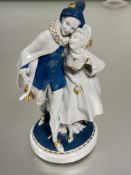 German Katzhutte porcelain figure group of a minstrel and lady with mask with blue and gilt
