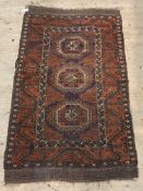 An antique Afghan bokhara rug, the madder ground with three guls enclosed by a geometric design to