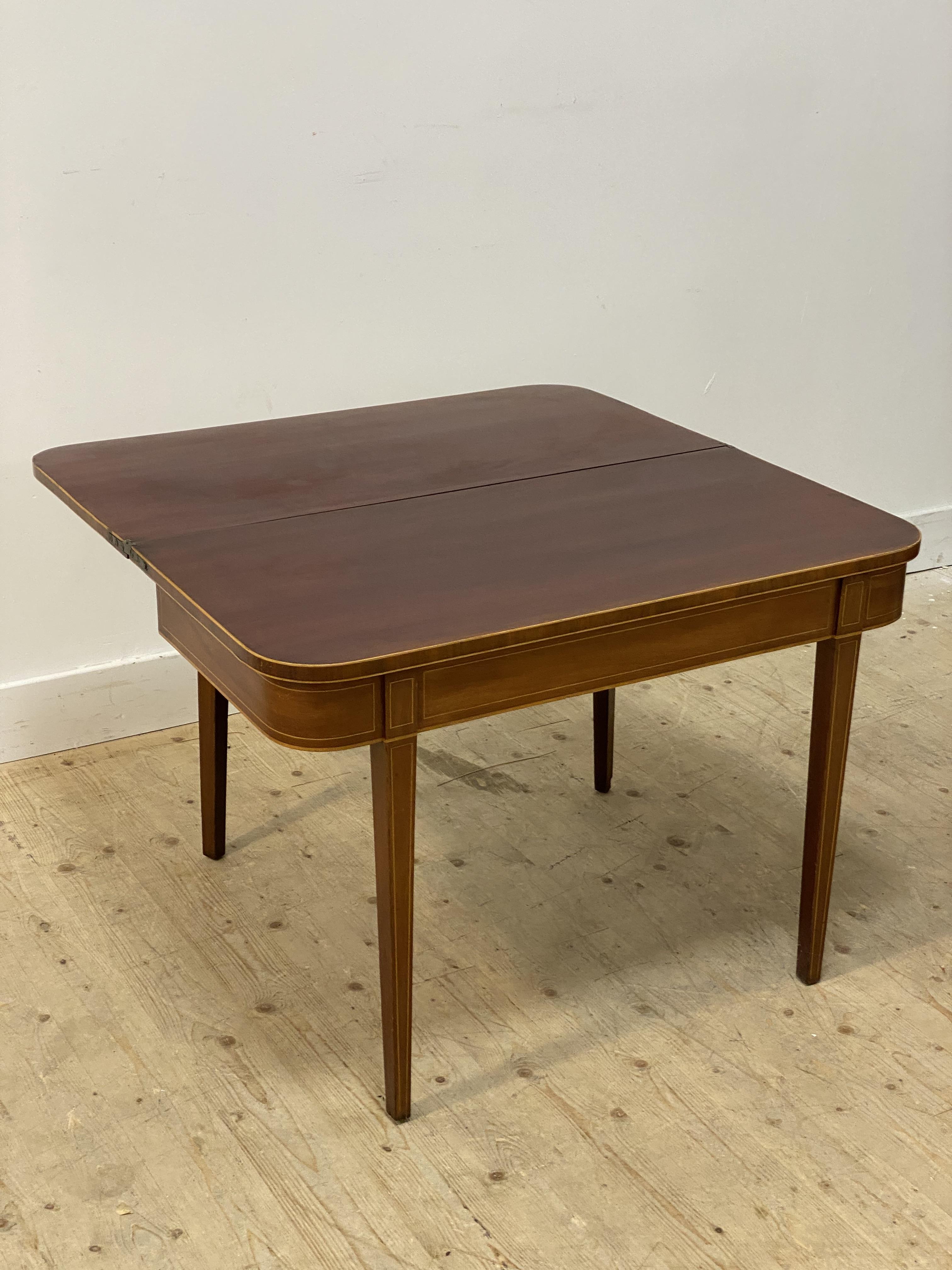 A George III mahogany fold over tea table, the top edge, frieze and square tapered supports with - Image 2 of 2