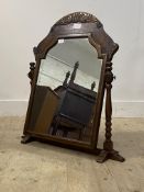 A Victorian oak and walnut toilet mirror, the floral carved pediment above a shaped mirror plate