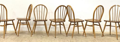 Ercol, a set of seven blonde elm and beech hoop and spindle back dining chairs, with saddle seats