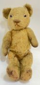 A 1920s mohair teddy bear with inset glass eyes, stitched nose, and linen paws (growl not