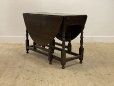 An oak gateleg table, 18th century and later, the oval top with two drop leaves above a drawer to