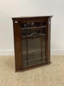 A late 19th century mahogany wall hanging corner cupboard, with dentil cornice above an astragal