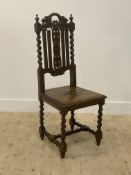 A Carolean style oak high back side chair with floral carved crest rail, splat and seat, raised on
