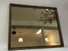 A 20thc decorative mirror in a gilt composition frame. (chip to corner) (57cmx46cm)