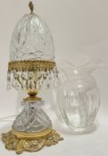 A moulded glass lamp lustre with gilt scrolling foliate mounts and putto/cherub finial (h- 41cm), to